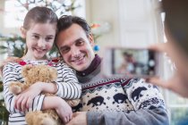 Батько і дочка позує для фотографії в різдвяні вітальні — стокове фото
