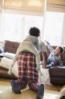 Padre e figli in pigiama che giocano in salotto — Foto stock