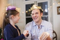Heureux père et fille en papier couronnes de Noël riant — Photo de stock