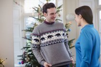 Mann zeigt Frau Weihnachtspullover — Stockfoto
