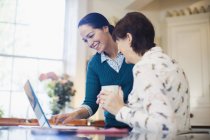 Daughter and senior mother using laptop in kitchen — Stock Photo