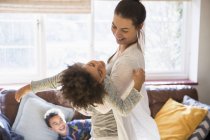 Playful mother and daughter in living room — Stock Photo