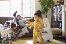 Giovane famiglia in pigiama che gioca in soggiorno — Foto stock