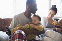 Щаслива багатоетнічна сім'я в піжамі, прикута до дивана — стокове фото