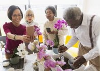 Personas mayores activas disfrutando de la clase de arreglos florales - foto de stock