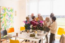 Personas mayores activas disfrutando de la clase de arreglos florales - foto de stock