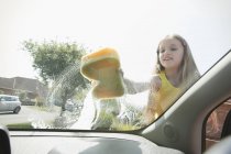 Girl washing car windshield — Stock Photo