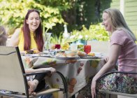 Lesbian couple and daughter enjoying lunch on patio — Stock Photo
