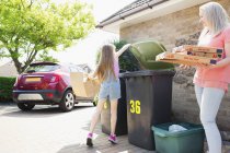 Mãe e filha reciclagem de papelão na entrada de carro — Fotografia de Stock