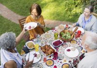 Seniorenfreunde genießen Mittagessen am Gartentisch — Stockfoto