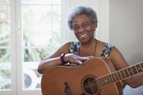 Retrato sonriente, mujer mayor activa confiada tocando la guitarra - foto de stock