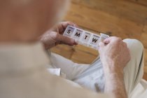 Homme âgé avec boîte à pilules à la maison — Photo de stock