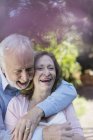Ласковая, улыбающаяся пожилая пара обнимается — стоковое фото