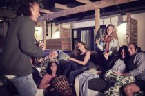 Happy friends hanging out, playing music on patio at night — Stock Photo