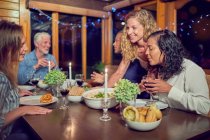Freunde genießen Abendessen in der Hütte — Stockfoto