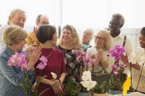 Heureux aînés actifs appréciant la classe d'arrangement de fleurs — Photo de stock