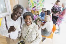 Портрет счастливая активная старшая пара наслаждается цветами аранжировки класса — стоковое фото