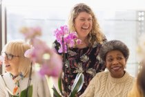 Instrutor feliz e idosos ativos desfrutando de aulas de arranjo de flores — Fotografia de Stock