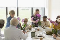 Активные пожилые люди наслаждаются классом аранжировки цветов — стоковое фото