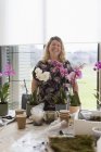 Портрет усміхненої жінки-інструктор, що викладає клас квіткової композиції — стокове фото