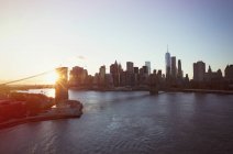 Vista del paisaje urbano de Nueva York y Brooklyn Bridge al atardecer - foto de stock