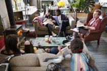 Estudiantes universitarios estudiando y pasando el rato en la sala de estar del apartamento - foto de stock