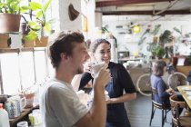 Счастливые соседи по комнате наслаждаются кофе на кухне квартиры — стоковое фото
