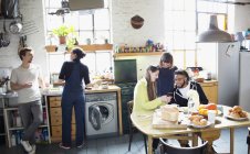 Giovani amici coinquilini adulti che si godono la colazione in cucina appartamento — Foto stock