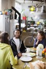 Jovens amigos companheiros de quarto adultos conversando na mesa de café da manhã no apartamento — Fotografia de Stock