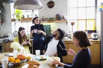Молодые друзья-соседи разговаривают за завтраком в квартире — стоковое фото