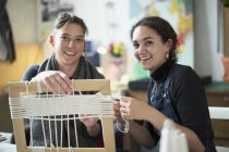 Retrato sonriente mujeres jóvenes amigos haciendo marco de cuadro de cuerda - foto de stock