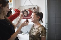 Young women friends getting ready, putting on makeup in bathroom — Stock Photo