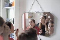 Молодые подруги готовятся, наносят макияж в зеркало ванной — стоковое фото