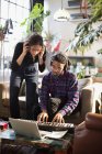 Young man and woman recording music, playing keyboard piano in apartment — Stock Photo