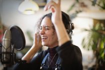 Giovane donna che registra musica, canta in microfono — Foto stock