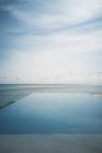 Tranquilo azul infinito piscina y el océano, Maldivas, Océano Índico - foto de stock