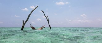 Junge Frau liegt in Hängematte über ruhigem blauem Ozean, Malediven, Indischem Ozean — Stockfoto