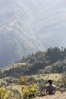 Wanderin, die sich ausruht und die Aussicht auf sonnige grüne Ausläufer genießt, supi bageshwar, uttarakhand, indische Ausläufer des Himalaya — Stockfoto
