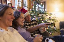 Сім'я відпочинку, дивляться телевізор в різдвяні вітальні — стокове фото