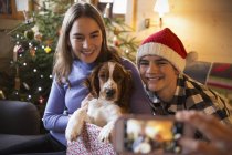 Брат и сестра позируют для фотографии с собакой в рождественской подарочной коробке — стоковое фото