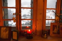 Bougie de Noël dans la fenêtre donnant sur un paysage enneigé tranquille, Forclaz, Suisse — Photo de stock