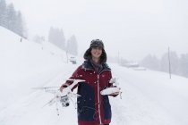 Retrato sonriente adolescente con dron en paisaje nevado - foto de stock