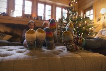 Familia con calcetines de colores relajante en la sala de estar de Navidad - foto de stock