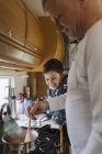 Father and son cooking in motor home — Stock Photo