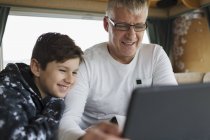 Pai e filho usando tablet digital em casa de motor — Fotografia de Stock