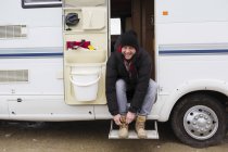 Portrait homme souriant attachant lacets de chaussure dans la porte du camping-car — Photo de stock