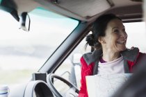 Mujer feliz con mapa en autocaravana - foto de stock