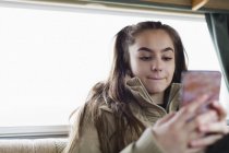 Дівчина-підліток смс зі смартфоном — стокове фото