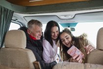 Famiglia felice con smart phone scattare selfie in camper — Foto stock