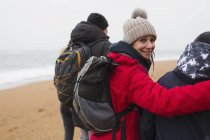 Ritratto donna sorridente con marito e figlio sulla spiaggia invernale — Foto stock